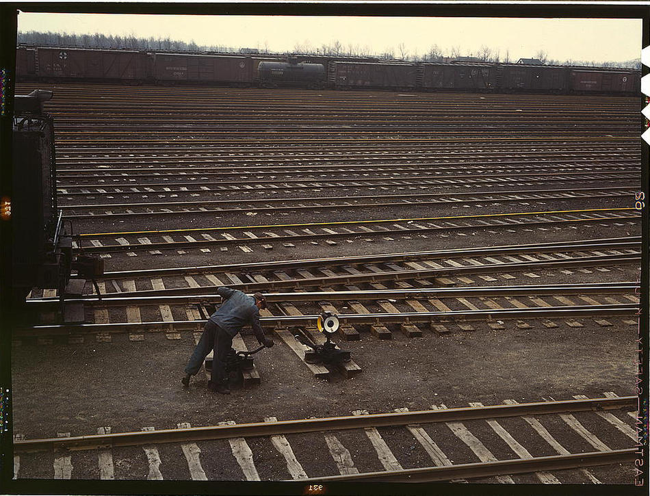 Switchman throwing a switch at Chicago and Northwest Railway Company Proviso yard Chicago, Illinois, April 1943. Photo by Jack Delano. Prints and Photographs Division, Library of Congress